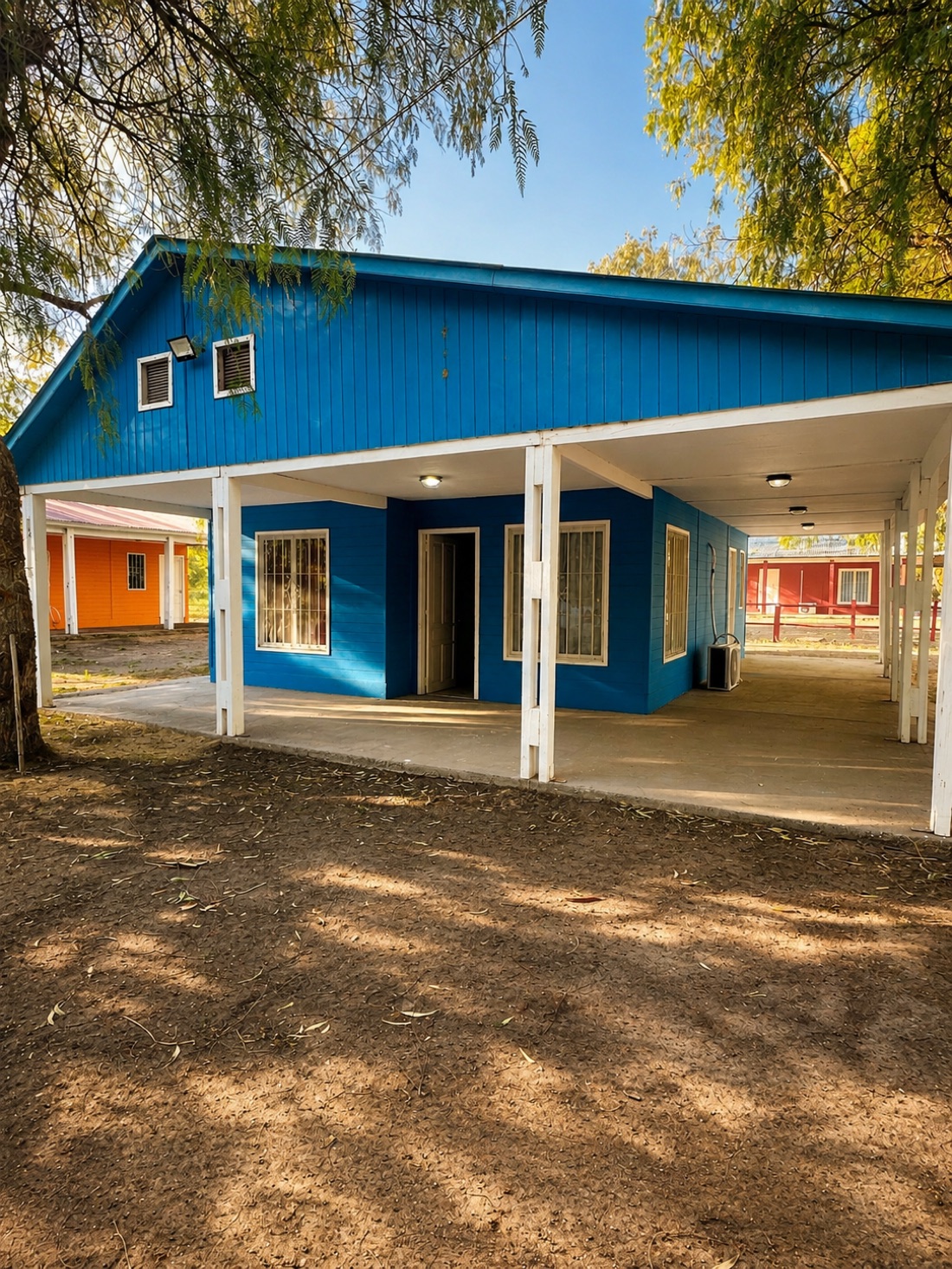Exterior de una cabaña azul entre los árboles